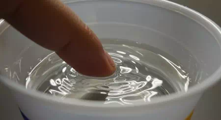 学食のコップに揺れる蛍光灯の光